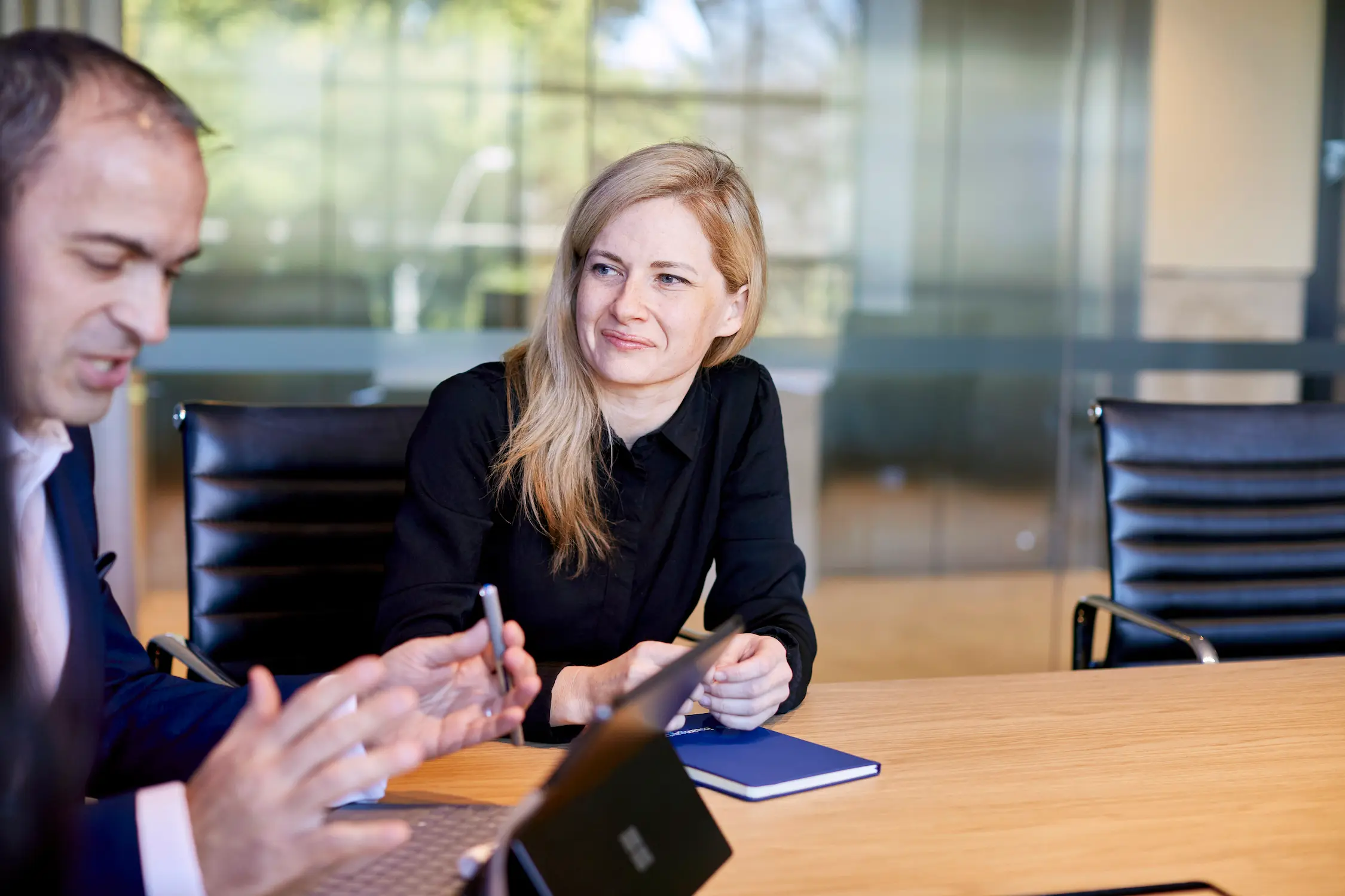 Woman and Man discussing at a boardroom table.
