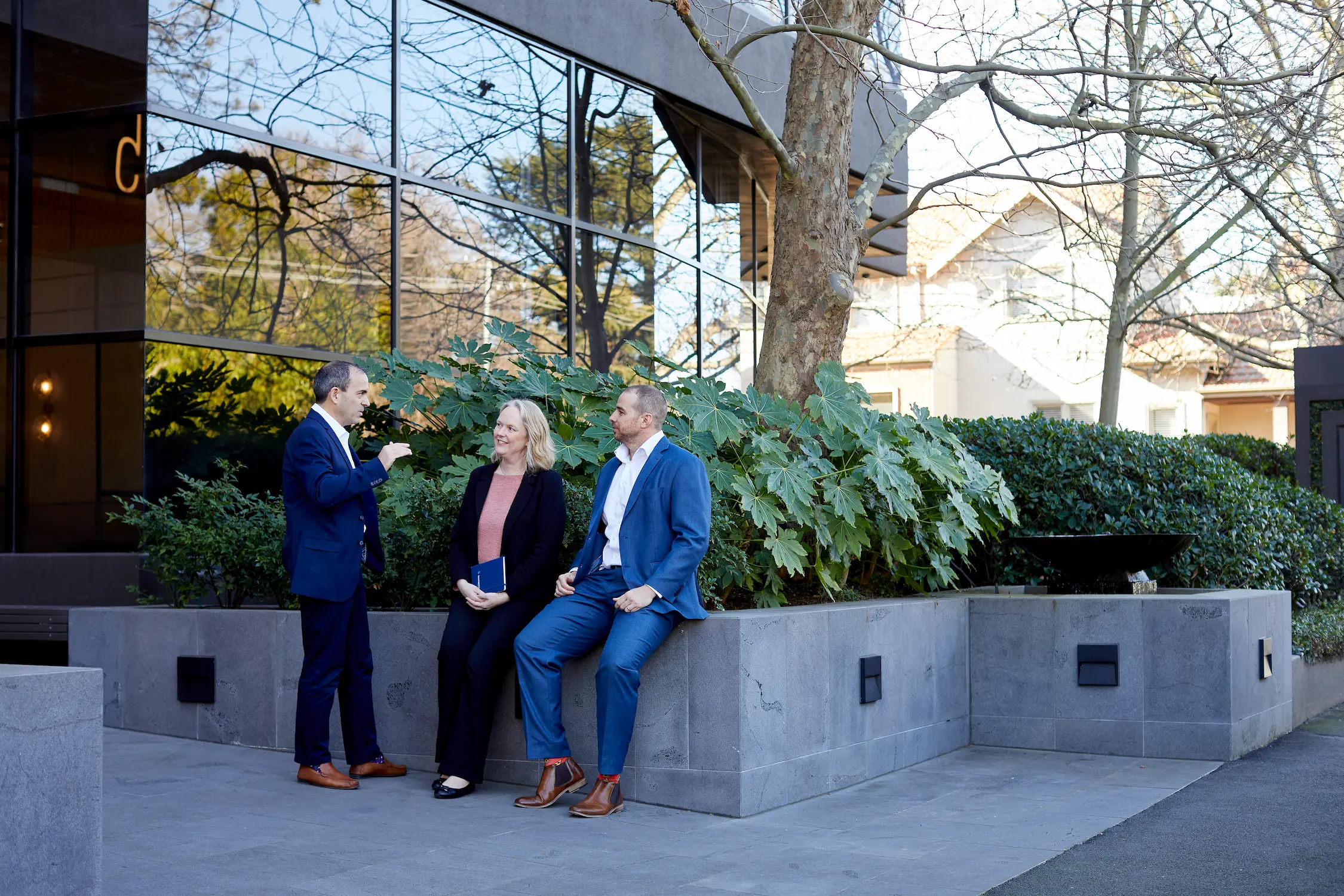 Three People standing outside the Baumgartners Office.