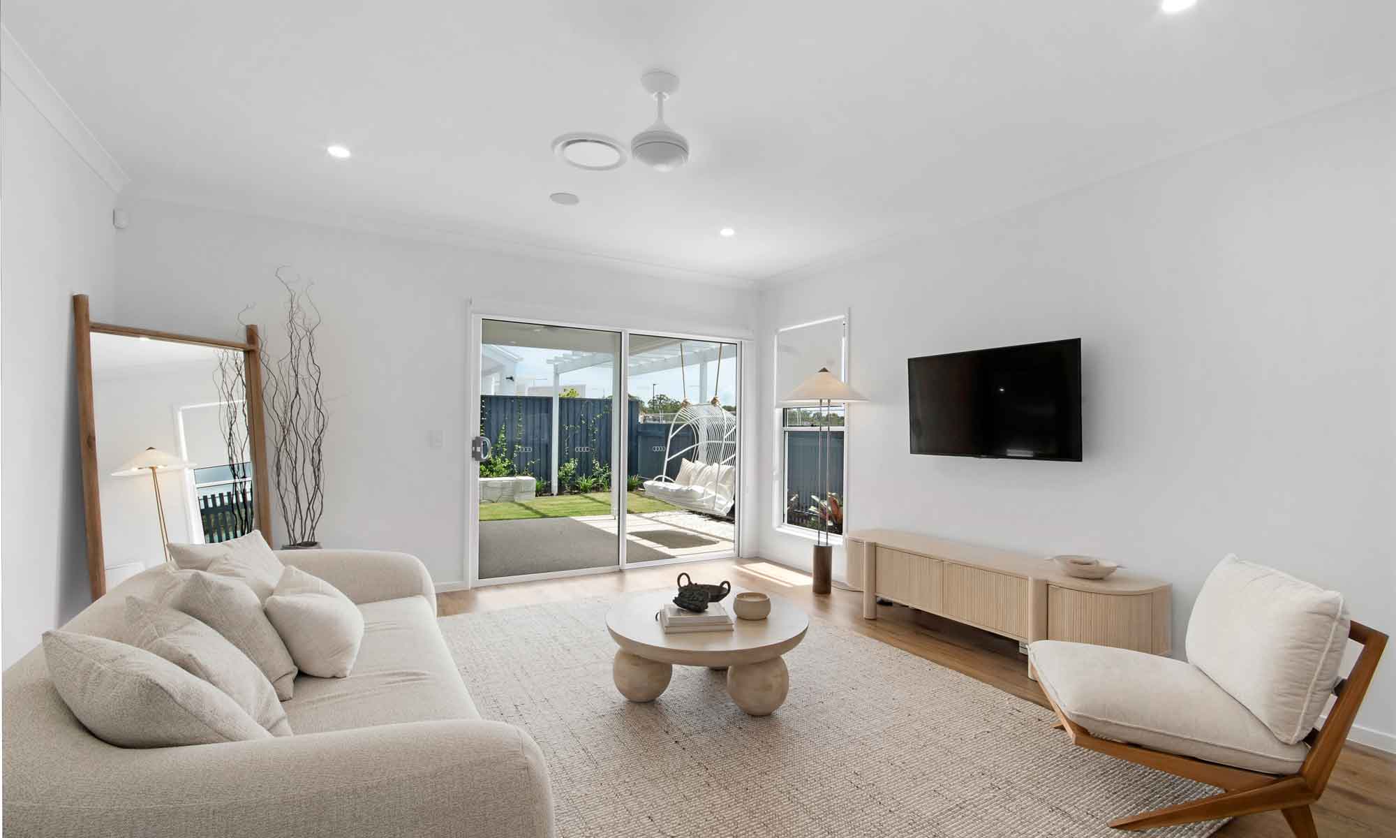 modern Australian style living room looking out to alfresco area with wicker swing chair