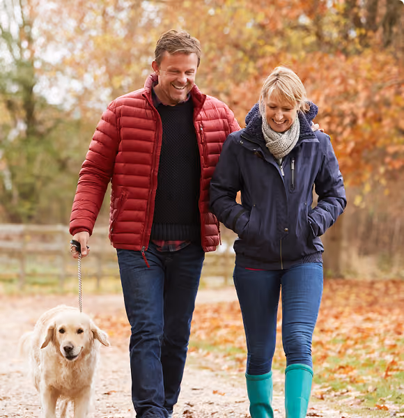 Couple walking their dog outdoors, representing Northeast Wealth's Taking the Lead financial planning service for people in their 40s