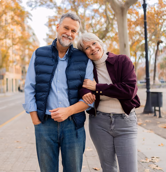 Retired couple walking arm-in-arm outdoors, representing Northeast Wealth's Building Momentum retirement planning service for people in their 60s