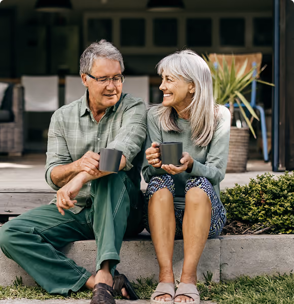 Couple relaxing together with coffee mugs on their porch, representing Northeast Wealth's Finding a Solution financial advice service