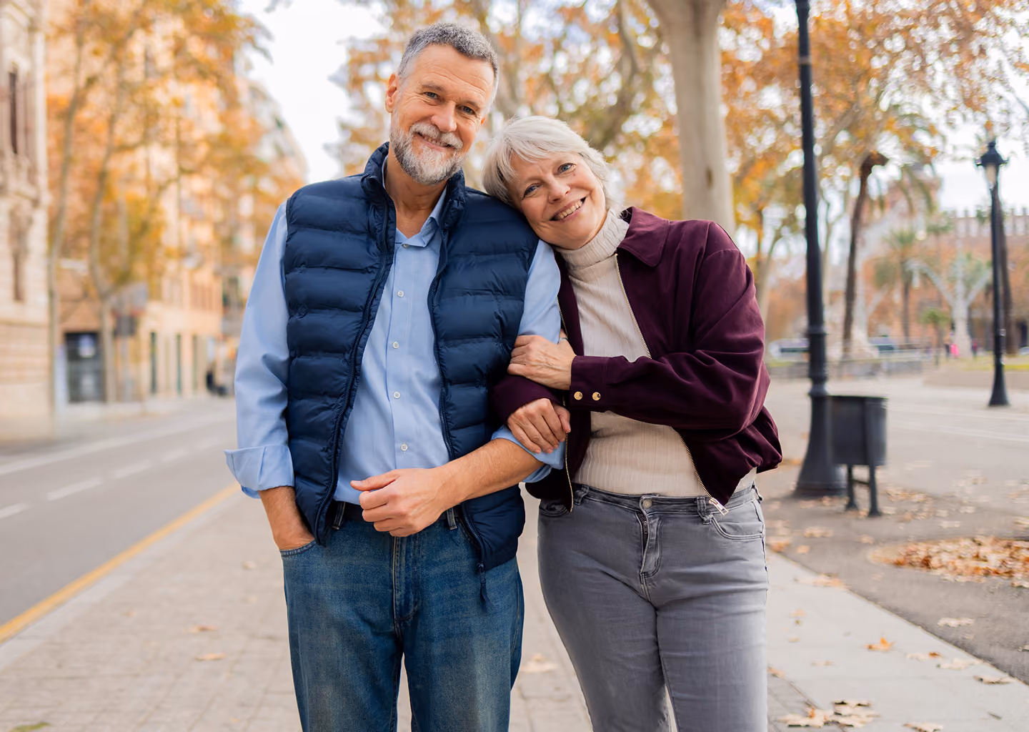 Retired couple walking arm-in-arm outdoors, representing Northeast Wealth's Building Momentum retirement planning service for people in their 60s