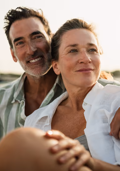 Smiling couple at the beach, representing Northeast Wealth's promise of direction — understanding where you are today and where you want to be tomorrow