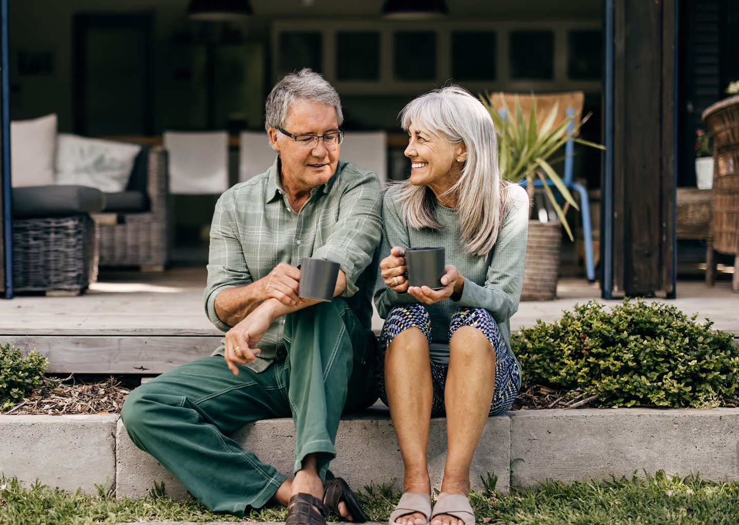 Couple relaxing together with coffee mugs on their porch, representing Northeast Wealth's Finding a Solution financial advice service