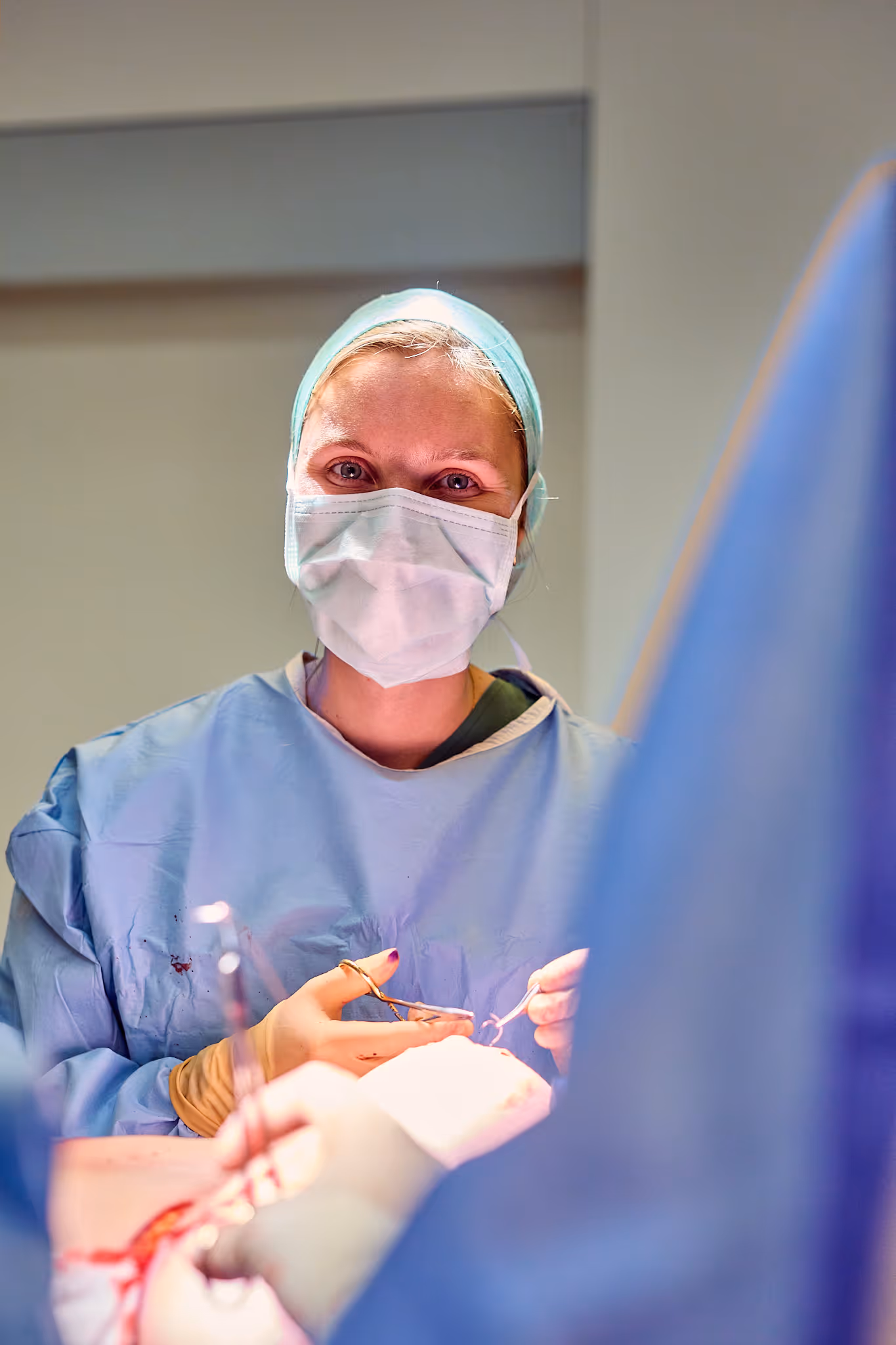  Vrouwelijke chirurg met mondmasker voert operatie uit in OK.