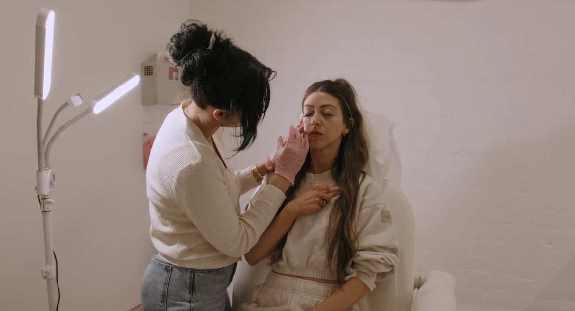 A LYEV Beverly Hills team member provides facial care to a seated client.