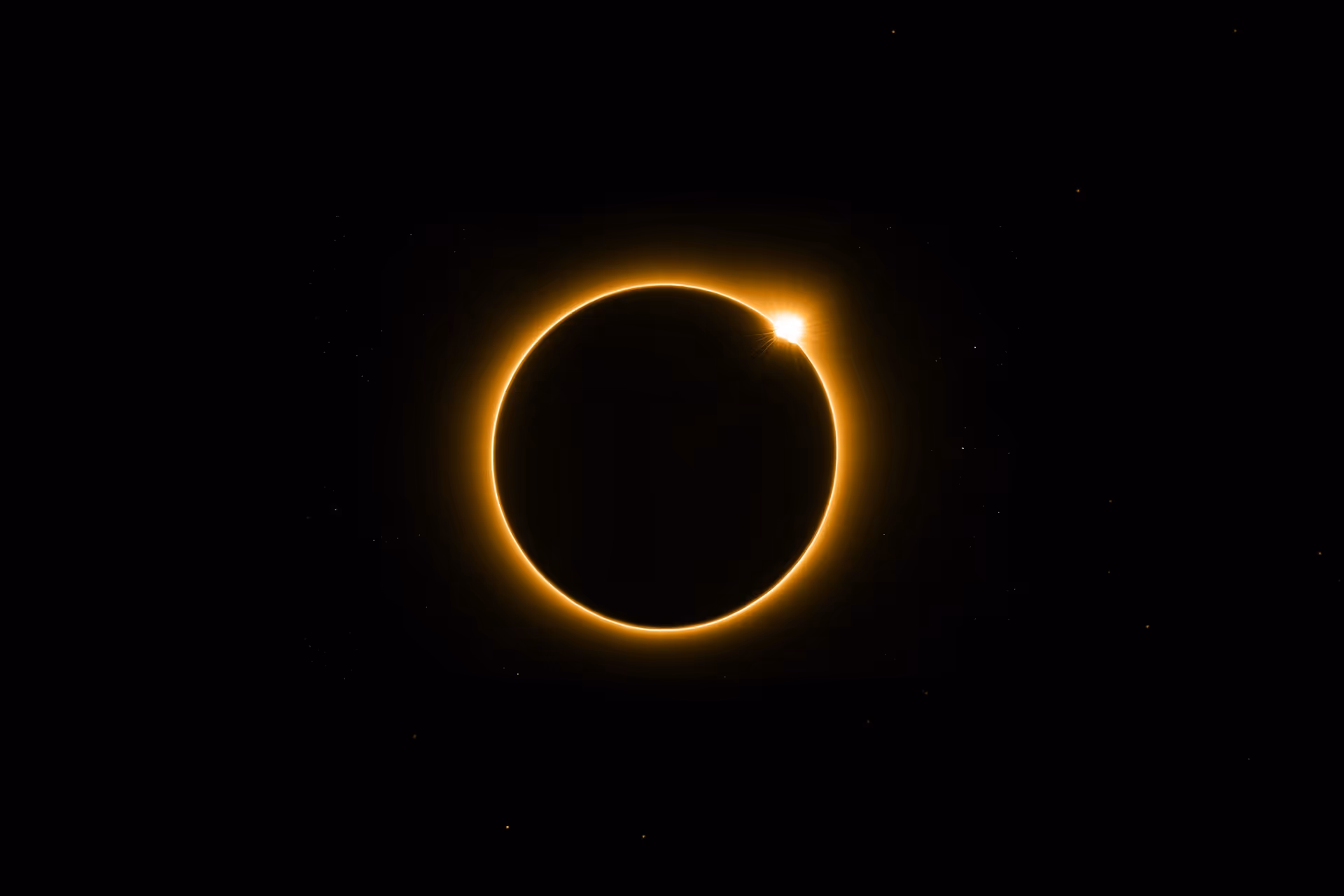 Solar eclipse showing the sun's glowing ring and a bright diamond effect on the edge.