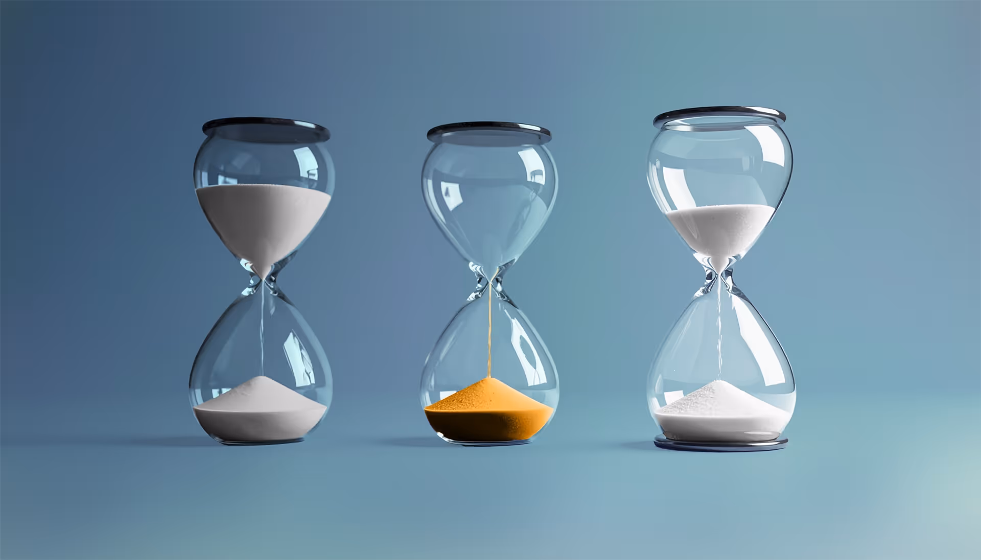 Three hourglasses on a blue surface; the left and right ones contain white sand, and the middle one contains yellow sand flowing downward.