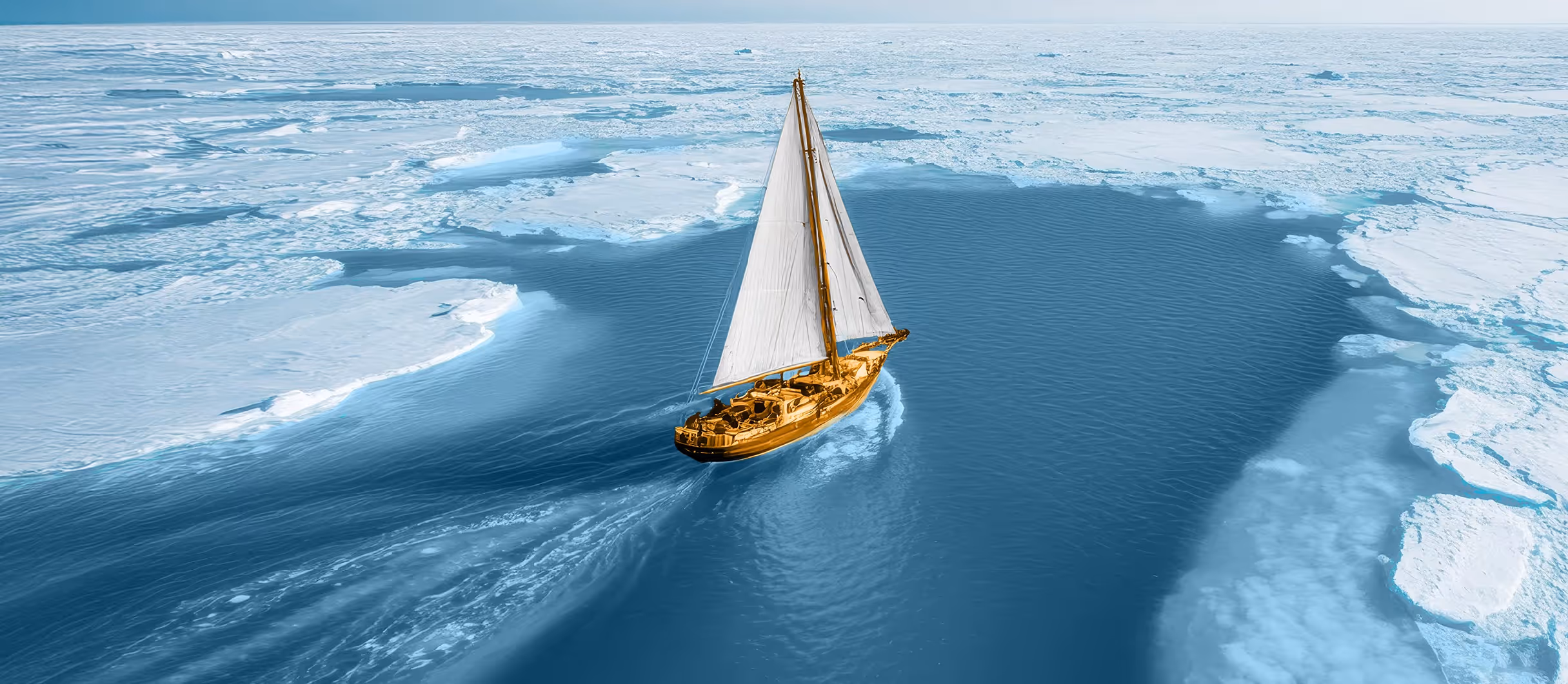 Sailboat with white sails sailing through a channel of open water surrounded by ice floes.