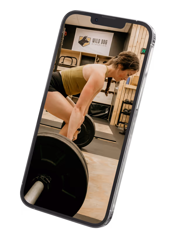 Coach Abby of Wild Dog Athletics deadlifting a barbell as seen on an iphone.