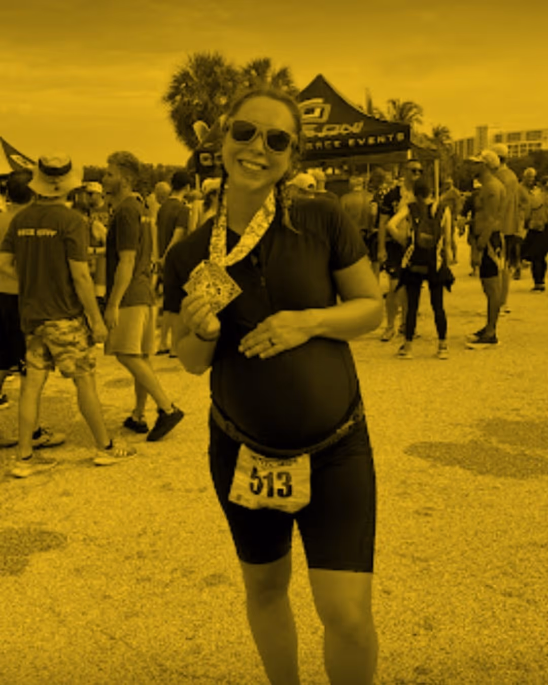 Wild Dog Athletics endurance runner client finishes her race posing with her medal.