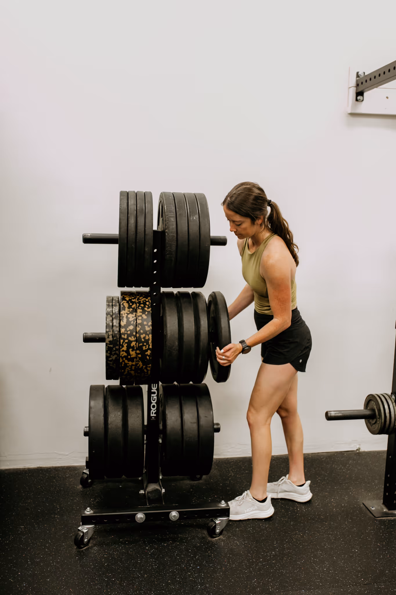 Coach Abby of Wild Dog Athletics placing free weights back in its place.