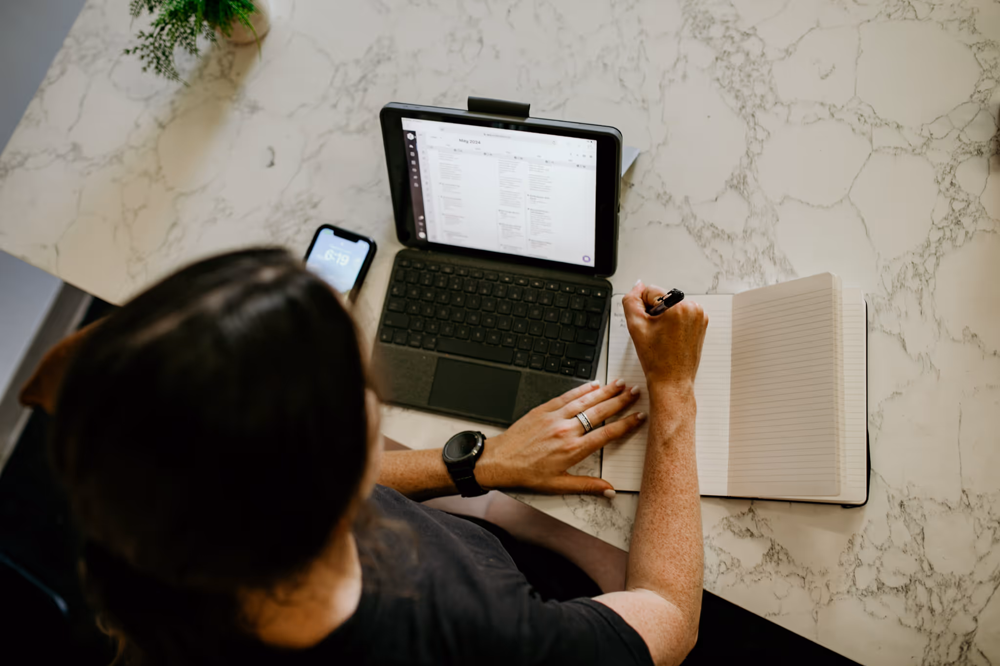 Coach Abby of Wild Dog Athletics is seen drafting a workout plan for her athletic remote client.