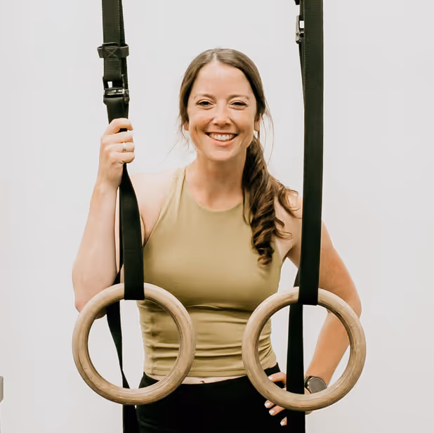 Coach Abby of Wild Dog Athletics poses in her athletic training gym.