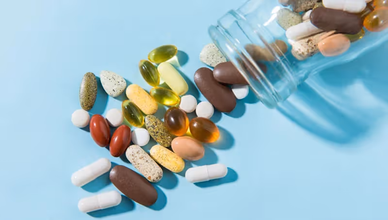 A jar filled with assorted pills and vitamins.