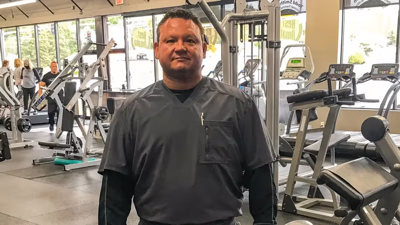Joe standing with a barbell in the gym