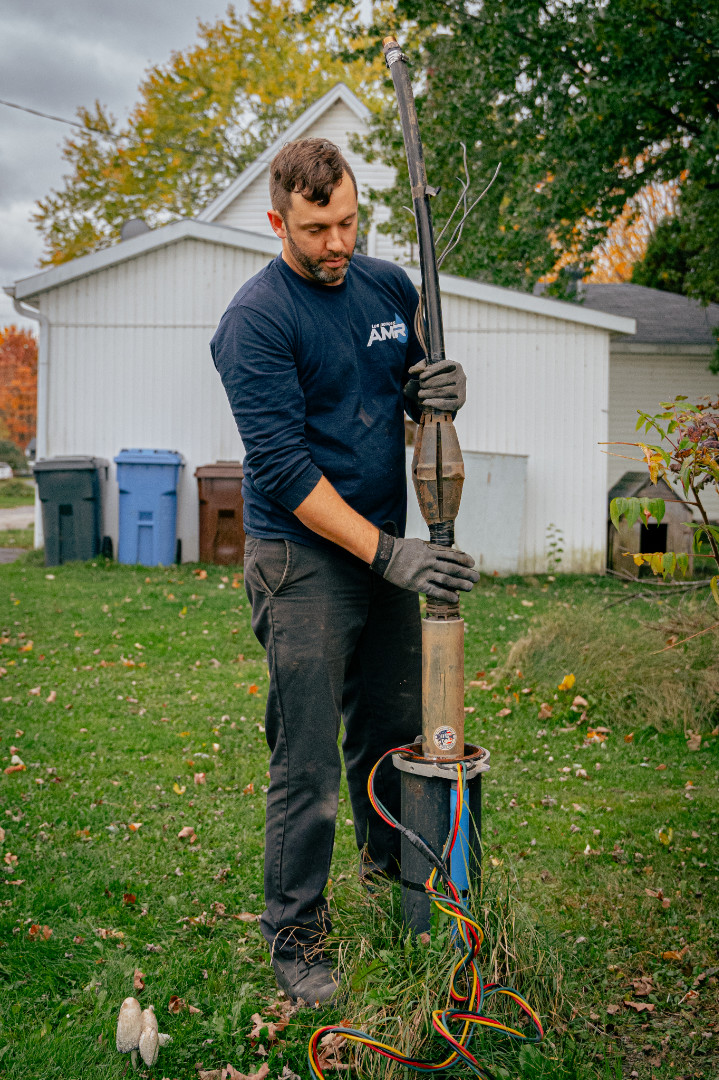 Technicien installant une pompe submersible pour puits artésien.