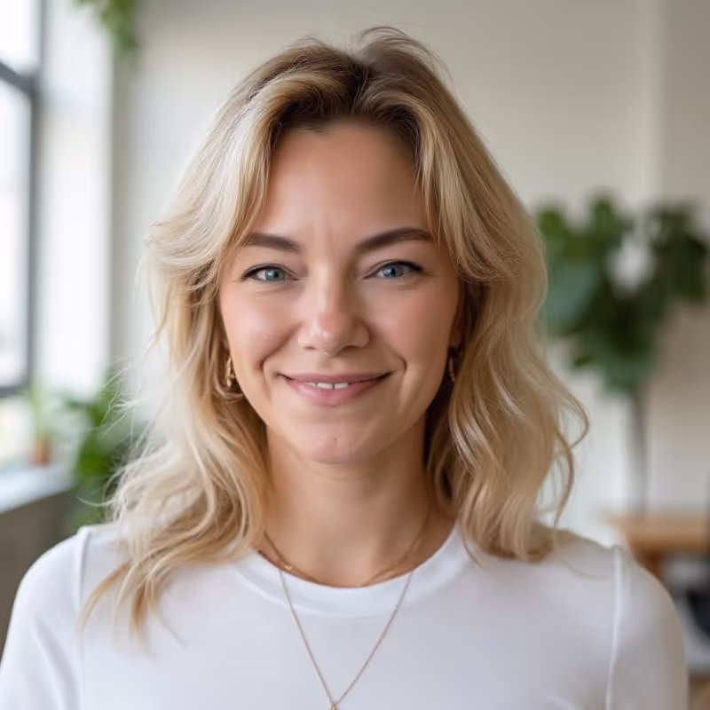 Porträtfoto von Christina Aberle, blonde Frau mit weißem Shirt, freundlich lächelnd.