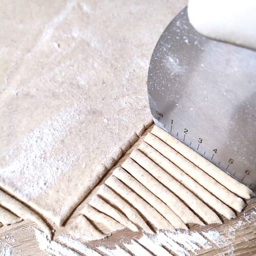 Découpe de la pâte en lanières à l'aide d'une corne de pâtissier