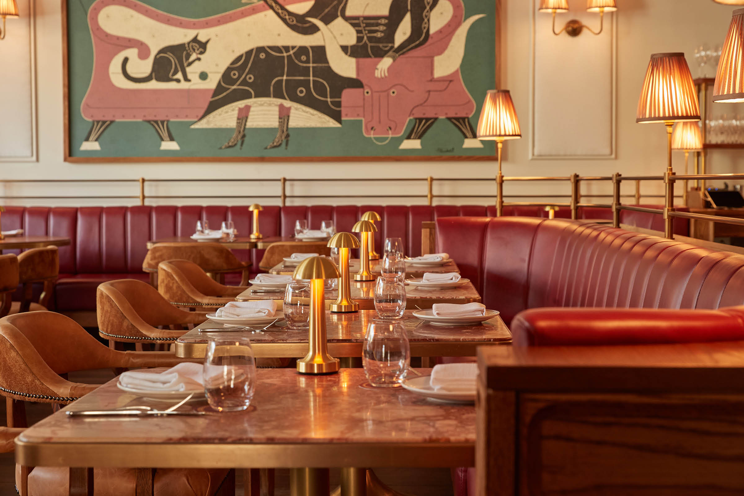 Lowlit tables beneath an illustrated mural artwork in the main dining room of Armorica, Surry Hills