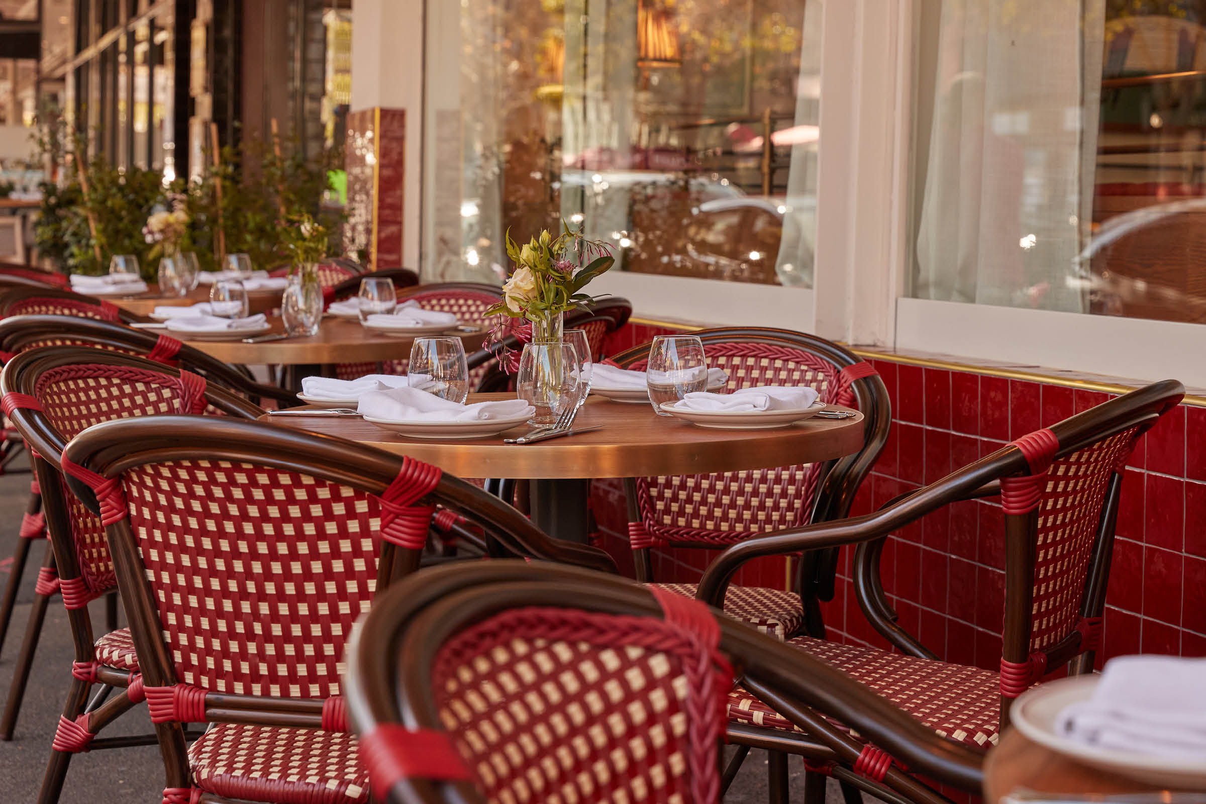 Red and cream rattan bistro chairs by the window at Armorica, a French brasserie in Surry Hills, Sydney
