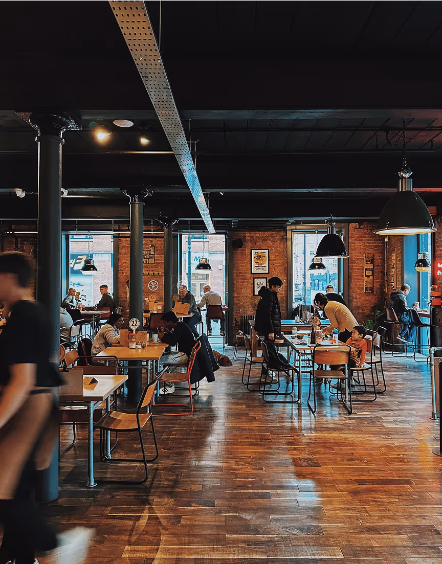 A group of people sitting at tables in a restaurant.