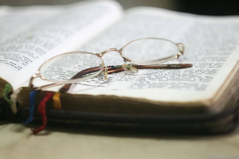 Aufgeschlagene Bibel mit Brille – welche Bibelübersetzung ist empfehlenswert