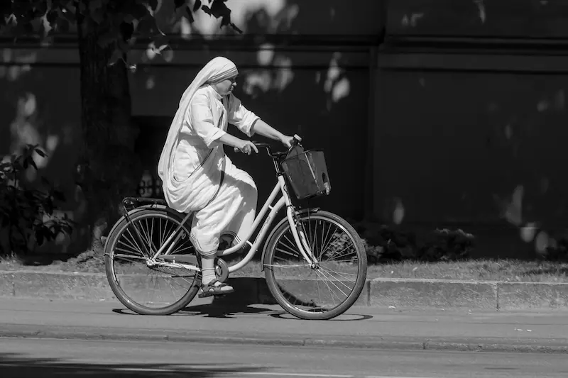 ine Nonne fährt mit dem Fahrrad – ein symbolisches Bild für den Lebensweg von Mutter Teresa und ihren Einsatz für bedürftige Menschen.