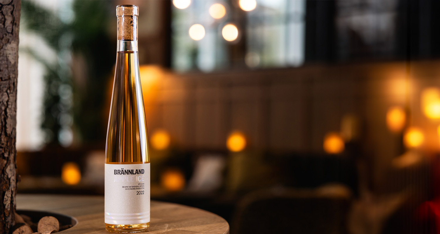 A bottle of Brännland Iscider on a wooden barrel.