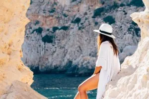 Woman on rocks looking at ocean