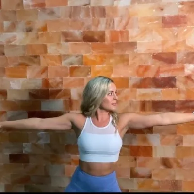 Woman doing yoga in front of a Himalayan salt panel wall at the The Salt Center - Alpharetta, Georgia.