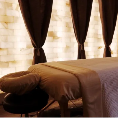 Massage table with a Himalayan salt brick wall and a LED backlit salt panel wall at Eleventh Element - Edwardsville, Pennsylvania.