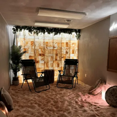a salt room with chairs and a Himalayan salt brick wall