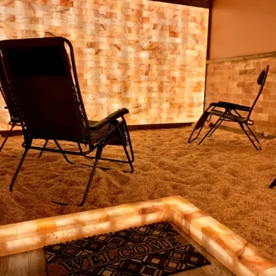 Just Breathe Salt and Spa Yoga Studio. View from behind lounge chairs facing tiled wall.