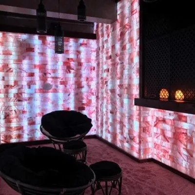 Two papasan chairs in a room with Himalayan salt-covered floors and LED backlit salt brick walls.