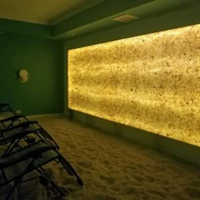 North Shore Salt Therapy Center. Three lounge chairs in smaller salt room facing lit up salt wall in a movie theater fashion