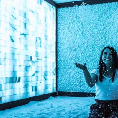 Salt - A Halotherapy Spa Woman in salt room, happily tosses salt into the air.