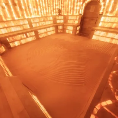 The Salt Cave at Synchronicities Sandy, Utah A brightly lit room with salt bricks on the wall and a bed of salt on the floor