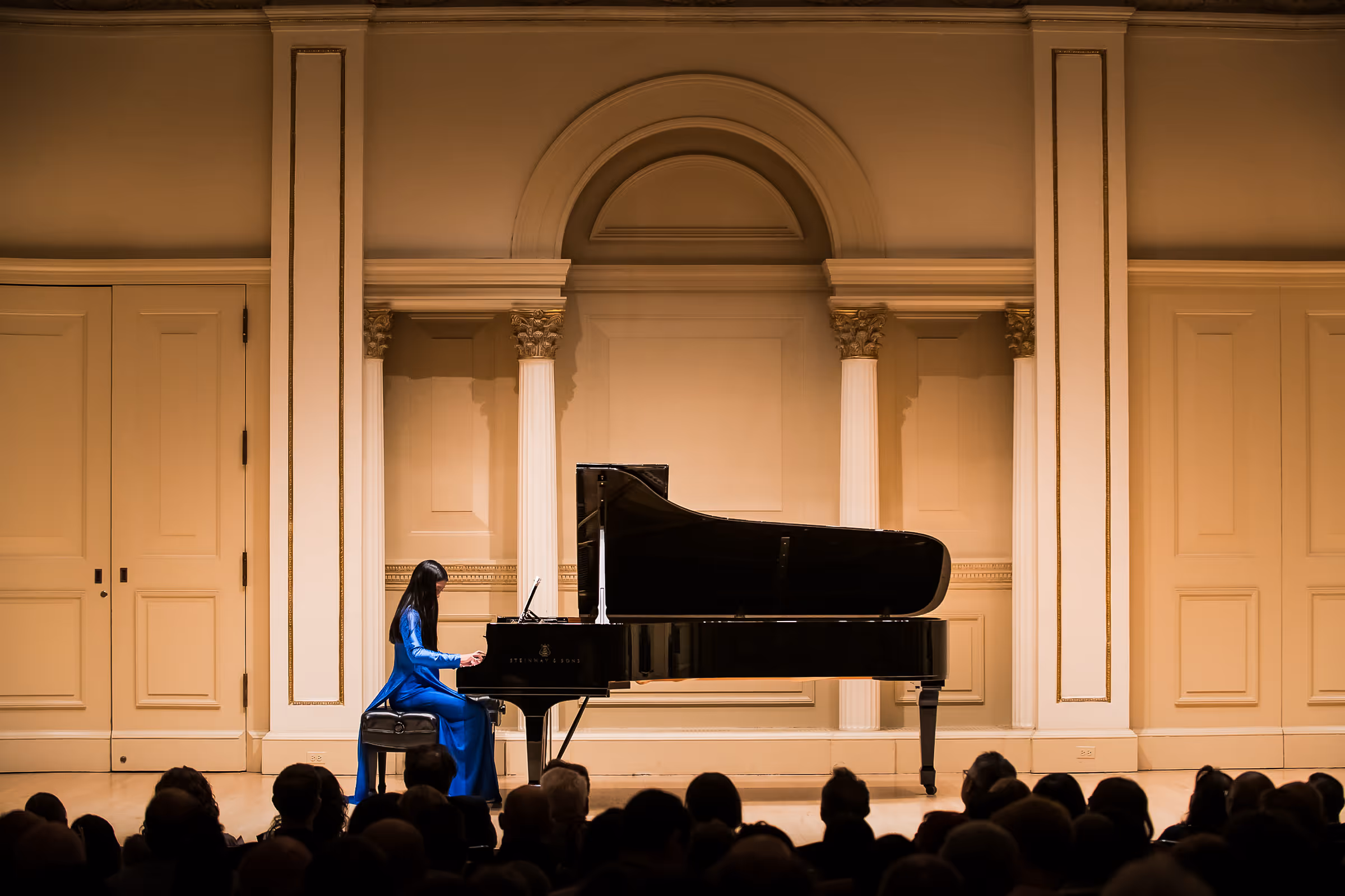 Girl in blue dress performing Piano in Carnegie Hall in New York City.