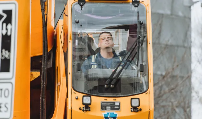 there is a man driving a bus on the street