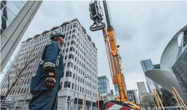 there is a man standing on a construction site with a crane