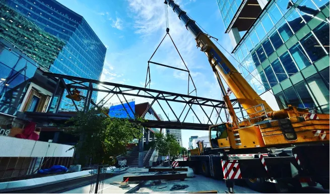 crane lifting a large piece of metal onto a platform