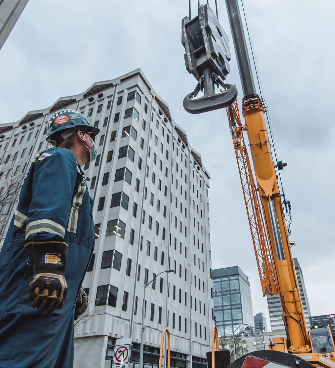 there is a man standing in front of a crane in a city