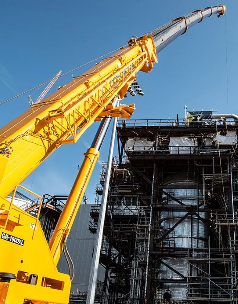 A large refinery with several cranes and pipes.