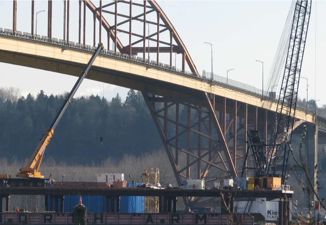 bridge with a crane and a barge in the water