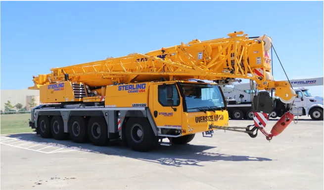 there is a yellow crane that is sitting in a parking lot