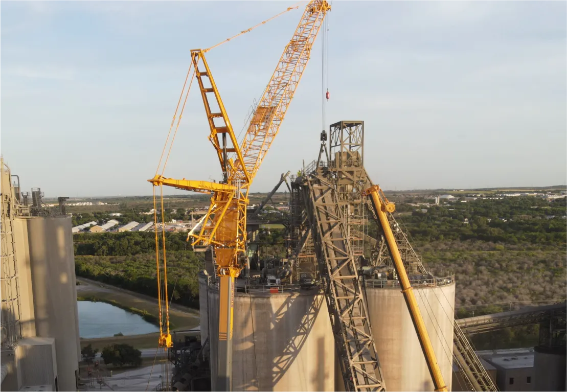 there is a crane that is standing on a building next to a body of water