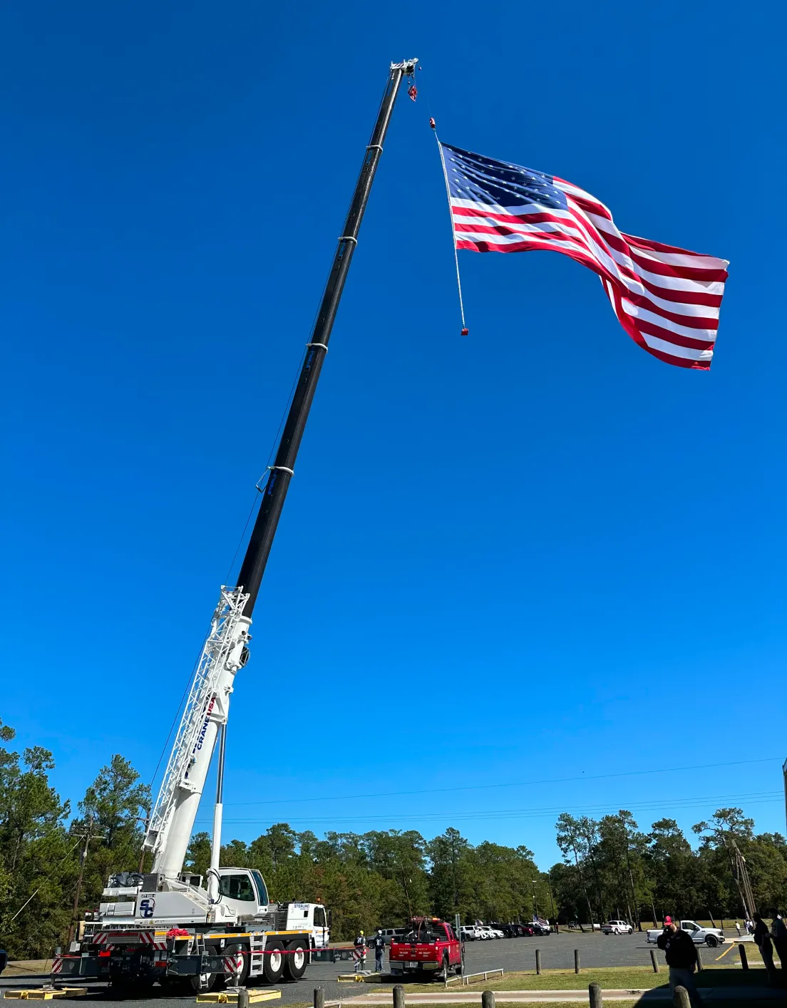 there is a large american flag flying on a crane