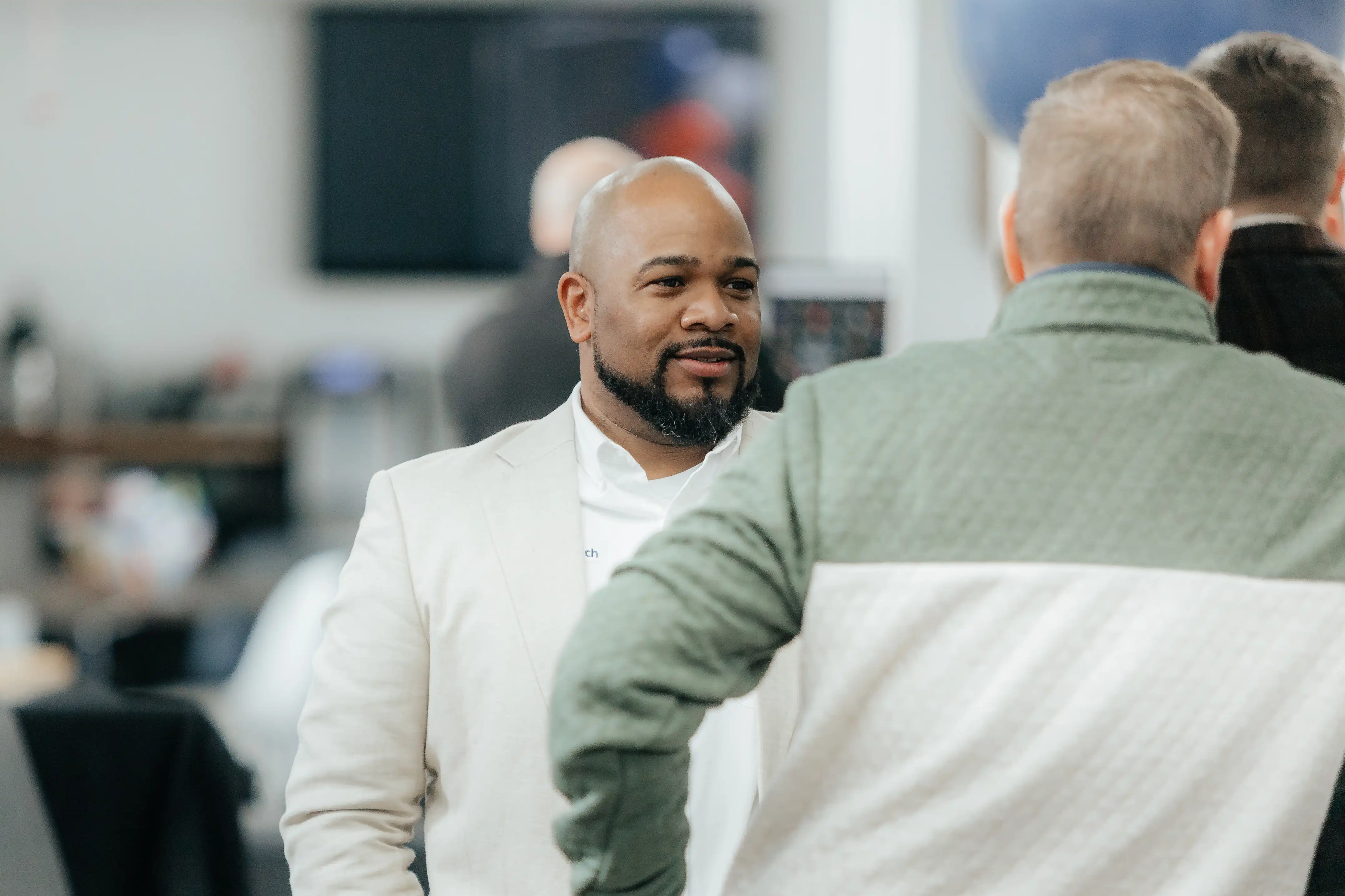 Team members talking and connecting in a collaborative office environment.